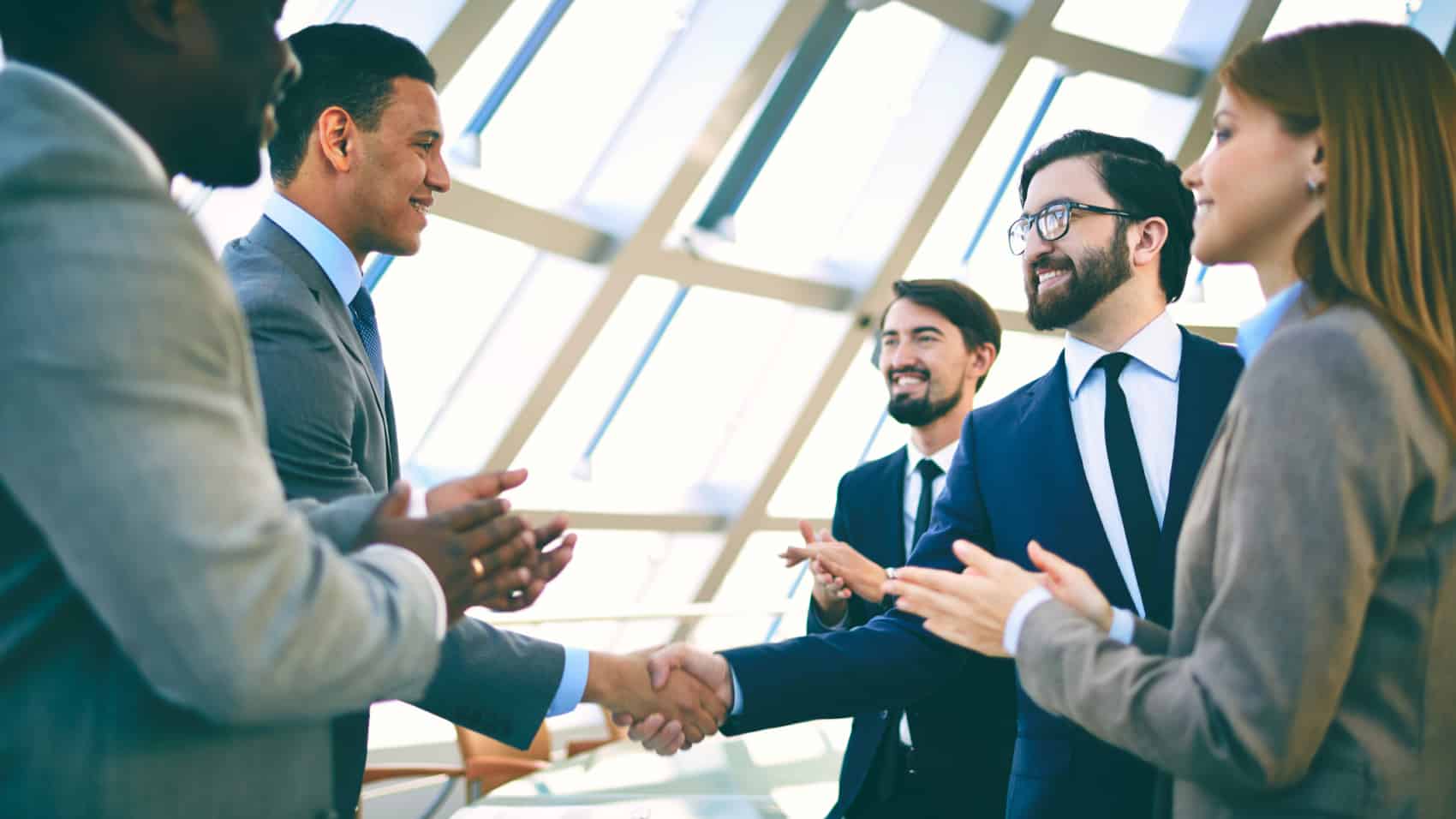 Business people shaking hands and clapping